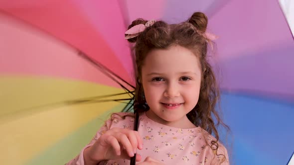 Girl with Space Buns Talks to Camera Playing with Umbrella alt