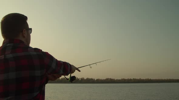 Crop Man Angling at Sunrise in Nature