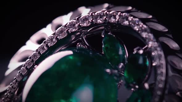 Brooch in with stones on a black rotating stand alt