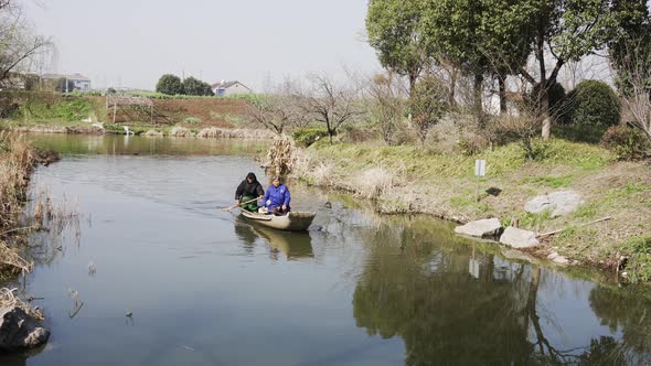 A Group Of Elderly Couples Rowing A Boat In A Small River V1