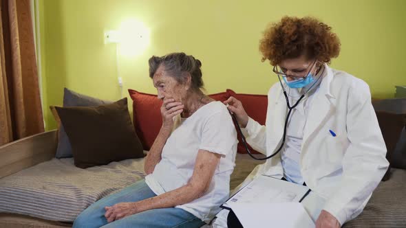 Mature Woman Doctor Holding Stethoscope Examining Senior Grandma Patient at Home alt