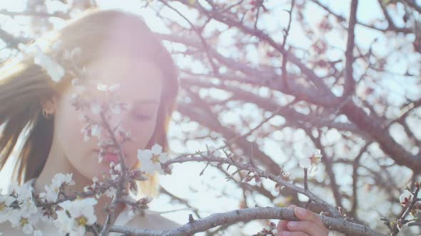 Beautiful Young Woman in the Sun Inside the Flowering Tree alt