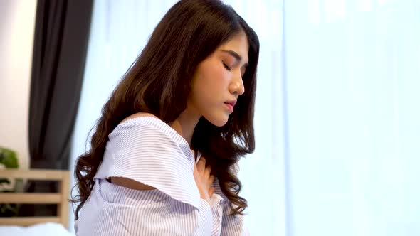 Young Asian Woman Having Shortness of Breath Asthma Difficult to Breathe Problems on Bed at Home alt