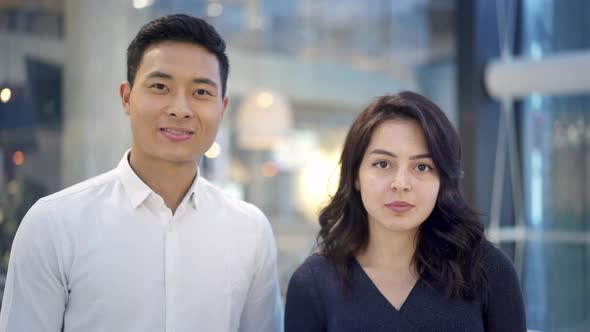 Portrait of Multiethnic Couple Standing on Background of Shopping Center