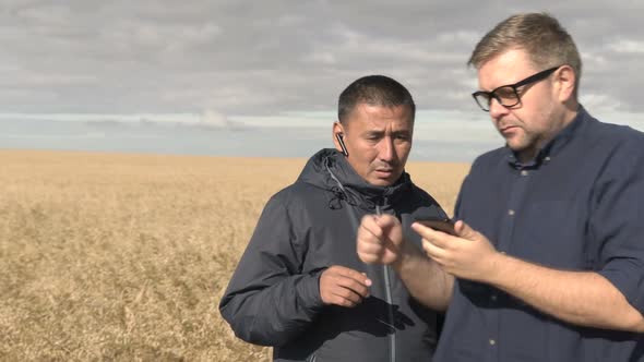 Businessman and Agronomist are Working with the Help of Agro Application on Smartphone alt