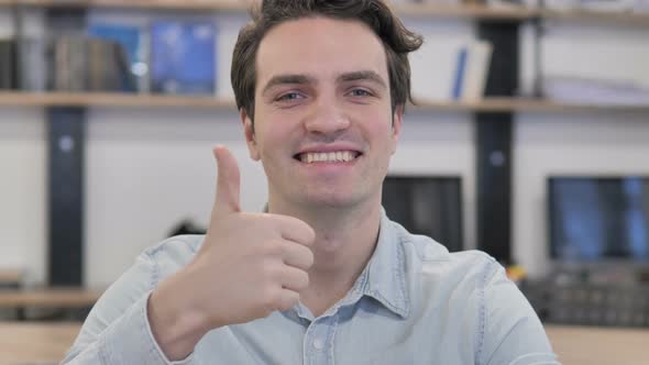 Thumbs Up By Creative Man Looking at Camera at Work alt