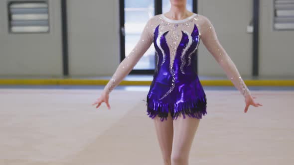 Teenage female gymnast performing at sports hall alt