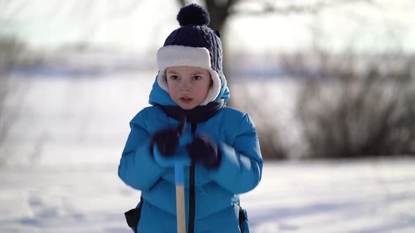 Little Boy Shoveling Snow at Winter alt