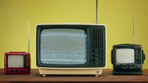 Old Televisions with Grey Interference Screen on Yellow Background alt