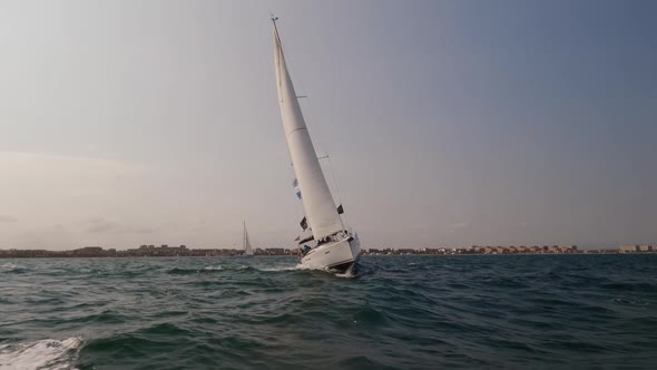 Front View of Sailboat Sailing in Slow Motion Over the City alt