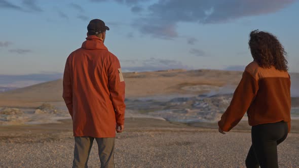 Tourist Couple Looking at the Majestic Lagoon on a Geothermal Field in Iceland alt