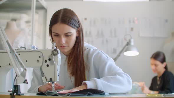 Front View Of Female Fashion Designer Working With Sewing Machine In Workshop alt