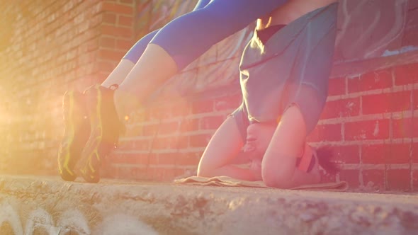 A young woman doing a headstand on the streets on an urban environment. alt
