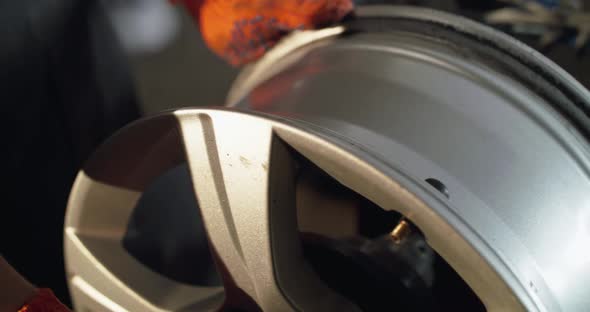 Unrecognizable Mechanic Rotates Alloy Wheel on Tyre Changer Machine on Service alt