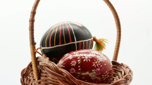 Decorative Basket with Painted Easter Eggs on White Background