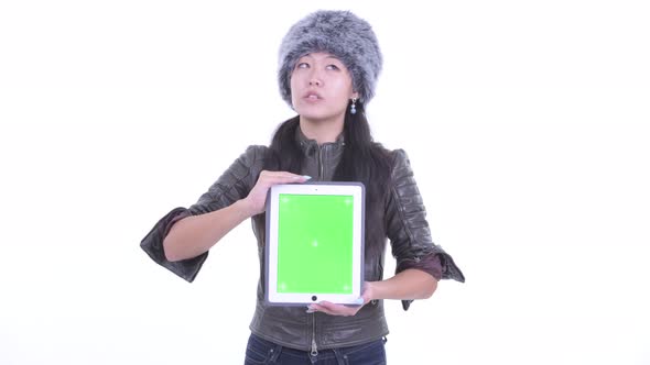 Happy Beautiful Asian Woman Thinking While Showing Digital Tablet alt