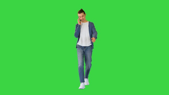 Young White Man Walks Talking on His Smartphone and Smiling on a Green Screen Chroma Key alt