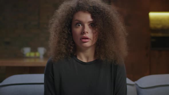 Millennial Woman Watching Scary Movie Sitting Alone on Couch alt