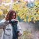 Beautiful Redhaired Woman Drinks Tea From Thermos in the Autumnal Forest