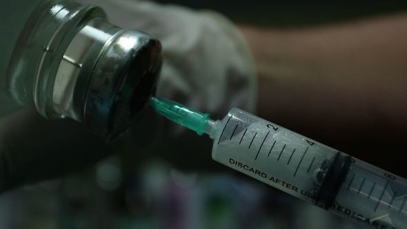 Injection Syringe Into the Jar