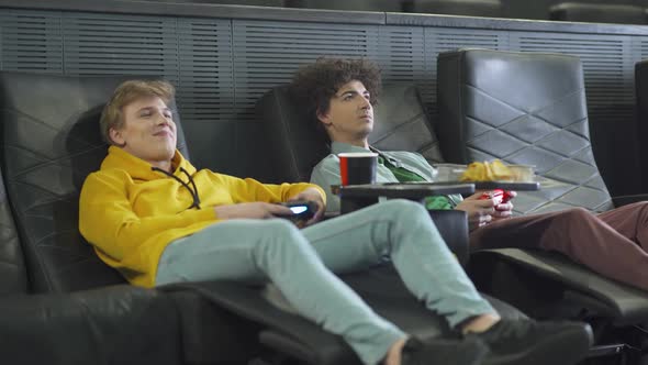 Young Friends in a Movie Theater Two Gamers Playing Video Games on a Game Console Playing Games on a alt