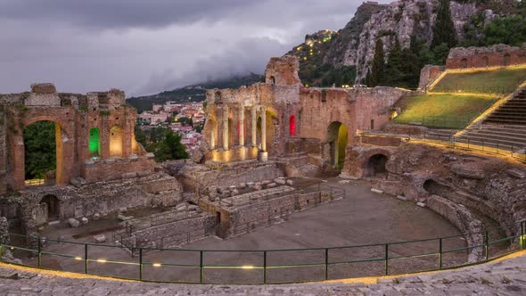 Sunset Time Lapse of Ruins of Ancient Greek Theatre in Taormina at Rainy Day. alt