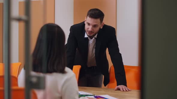 Portrait of Confident Successful Young Man Talking with Woman in Office Leaning at Table alt