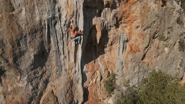 Slow Motion Aerial Drone Footage of Strong Man Rockclimber Climbing Up on Tough Hard Route on alt