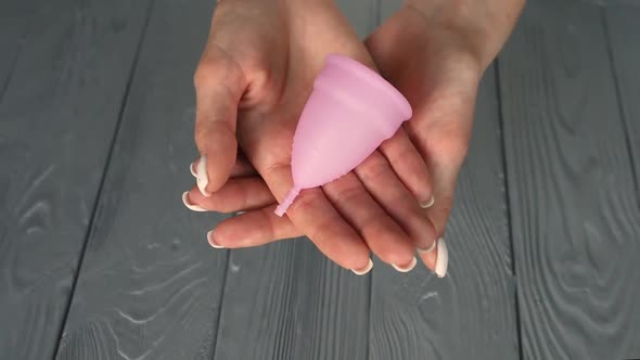 Close Up Menstrual Cup Latex Silicone Girl Looking Holding Hands Compress Folding alt