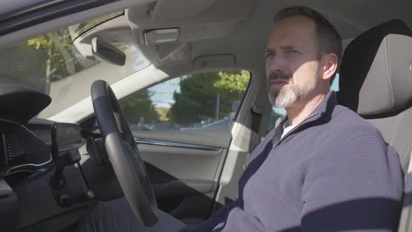 A Middleaged Handsome Caucasian Man Talks to Someone As He Sits in His Car  Closeup