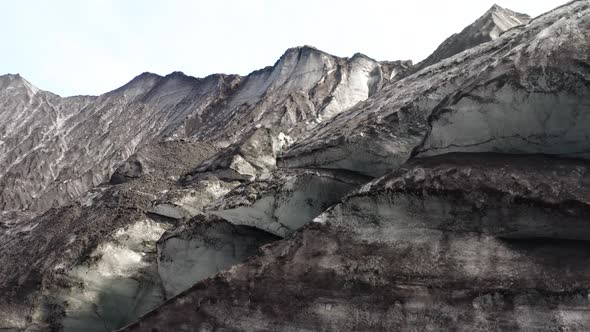Pull up shot of a Glacier in Iceland, Sunny Day and the Ice is covered by Ash alt