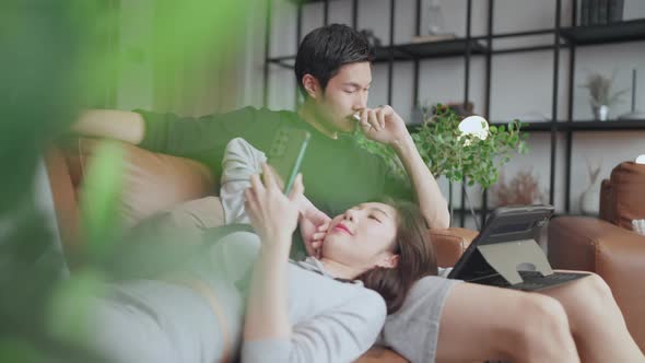 couple sit relax on sofa couch enjoy smartphone and peaceful conversation