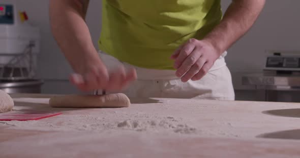 Slow Motion of Hands of Baker Chef Applying Flour on Dough alt