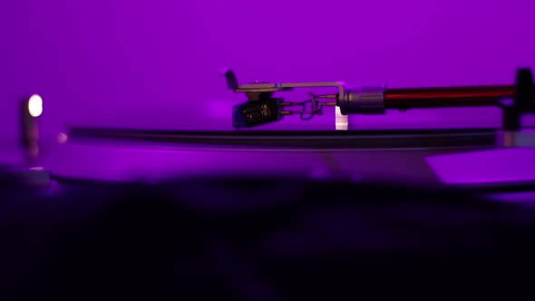 A Vintage Record Player Needle spins a warped and distorted record under a black light while a Disk alt