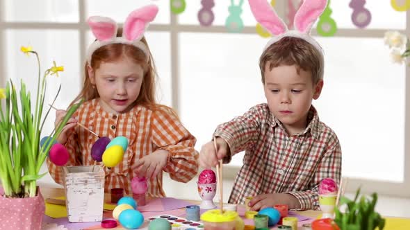 Happy Children Wearing Bunny Ears Painting Eggs on Easter Day