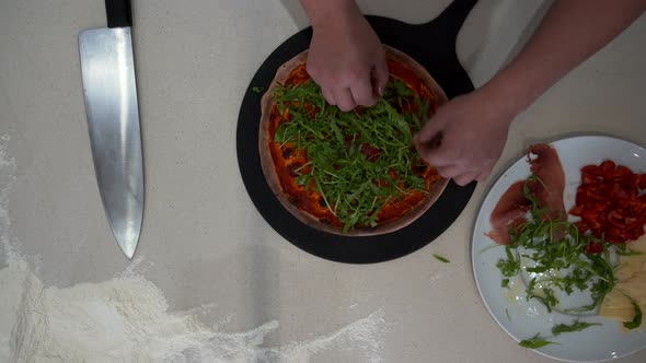 Top Down View of a Chef Making Pizza with Various Condiments alt
