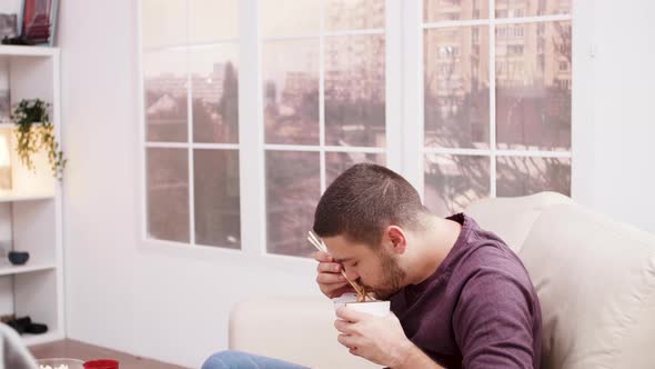 Bearded Man Enjoying a Box with Chinese Noodles alt