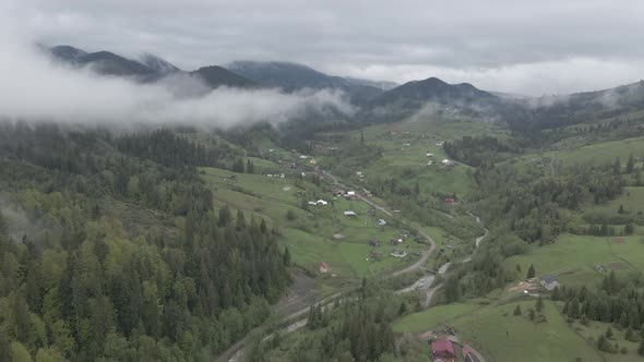Village in the Mountains. Slow Motion. Carpathians. Ukraine. Aerial. Gray, Flat alt