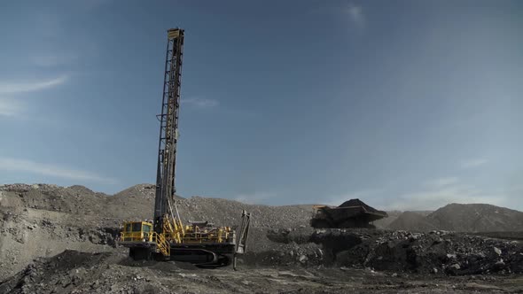 Drilling Rig for Assessing Thickness of Coal Seam Against Background of Quarry and Passing Truck