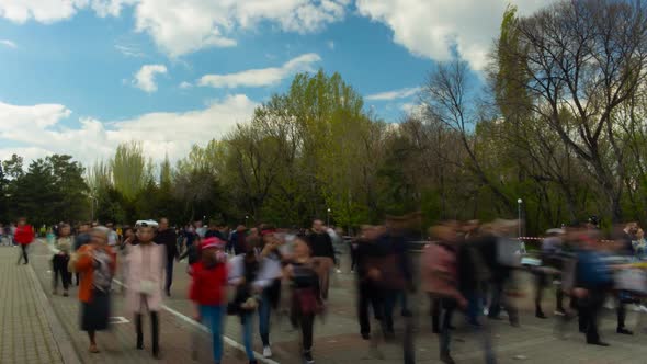 Time Lapse Walking People on Background Blue Sky Clouds and Trees