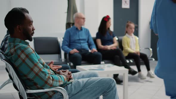 Portrait of African American Patient Sitting on Chair in Waiting Room alt