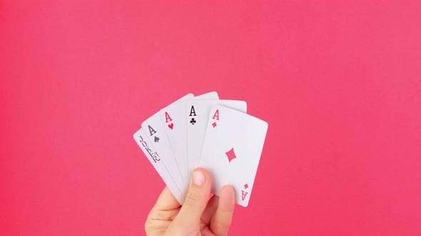 Five of a kind Poker Game cards in gambler hand falling money bills pink background Online gambling