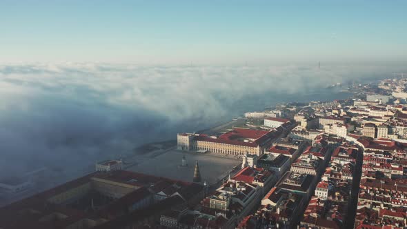 Panoramic view of Lisbon; old yellow rooftops in Portuguese capital and thick fog from Teju river