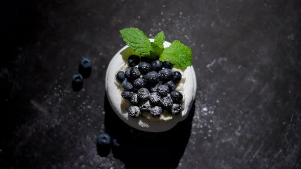 Mini Meringue Dessert Pavlova Cake with Fresh Blueberries Plased on Dark Rusty Table