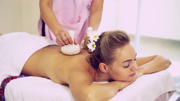 Massage Therapist Using Herbal Compress on Woman alt