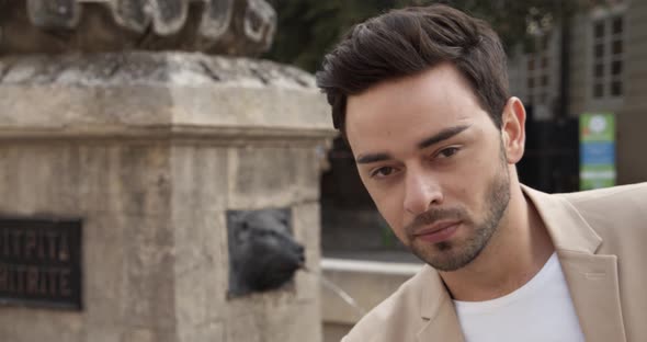 Handsome Young Guy Standing By The Fountain alt