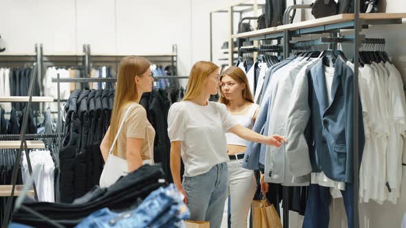 Women Shopping at Menswear Store Choosing Clothes for Boyfriend alt