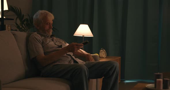 Elderly man watching television at night