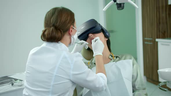 Dentist Works, Girl Sits with Virtual Reality Glasses alt