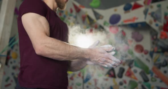 Young Bearded Athlete Clapping Hands with Chalk Powder Preparing for Training alt
